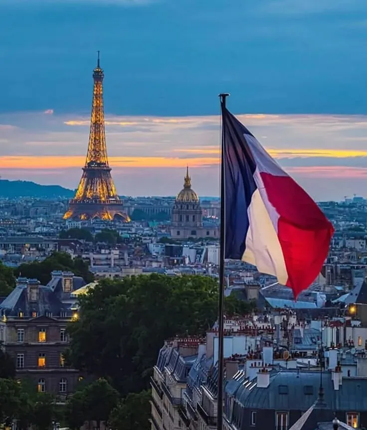 Hot Deals for Locals — the Eiffel Tower at dusk with a French flag