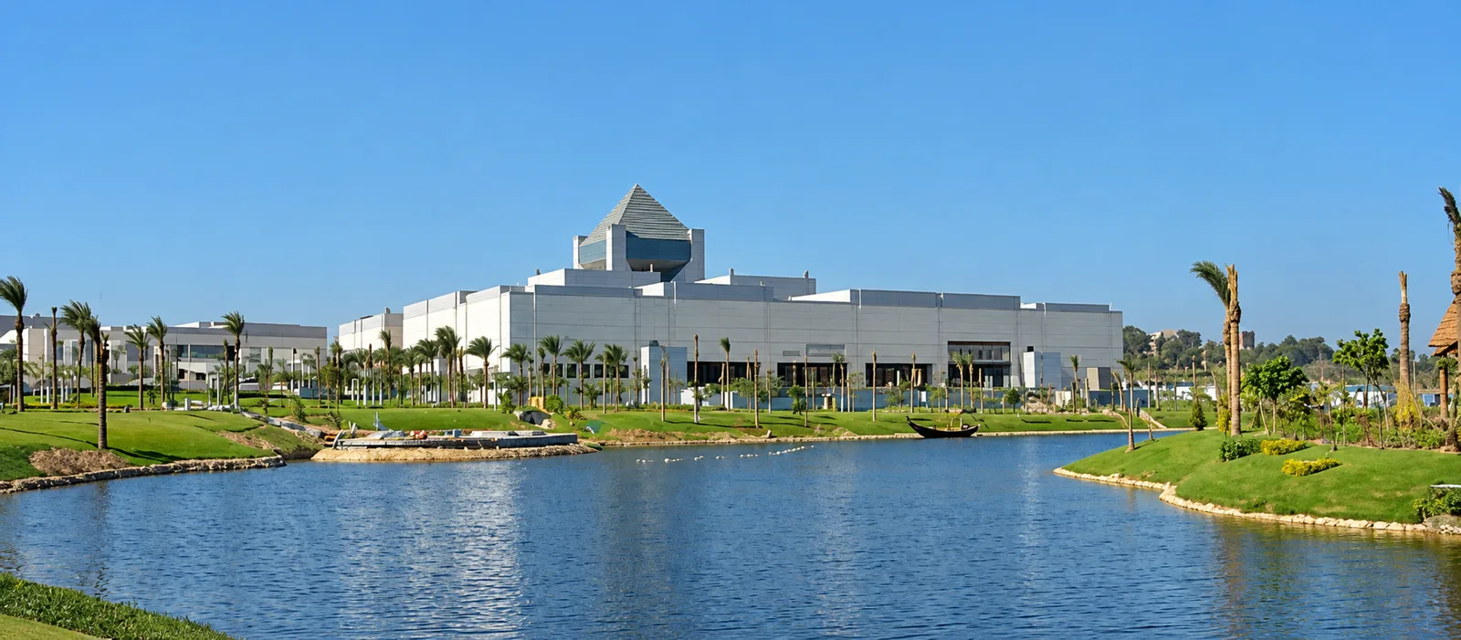 The National Museum of Egyptian Civilization beside its lake, with a pyramid-shaped roof
