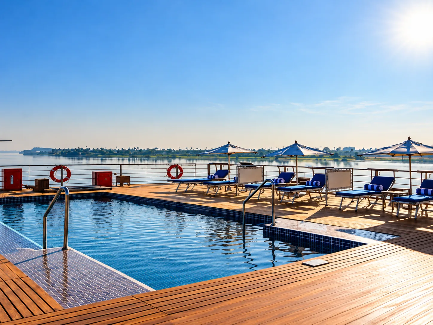 A sunlit riverfront pool deck